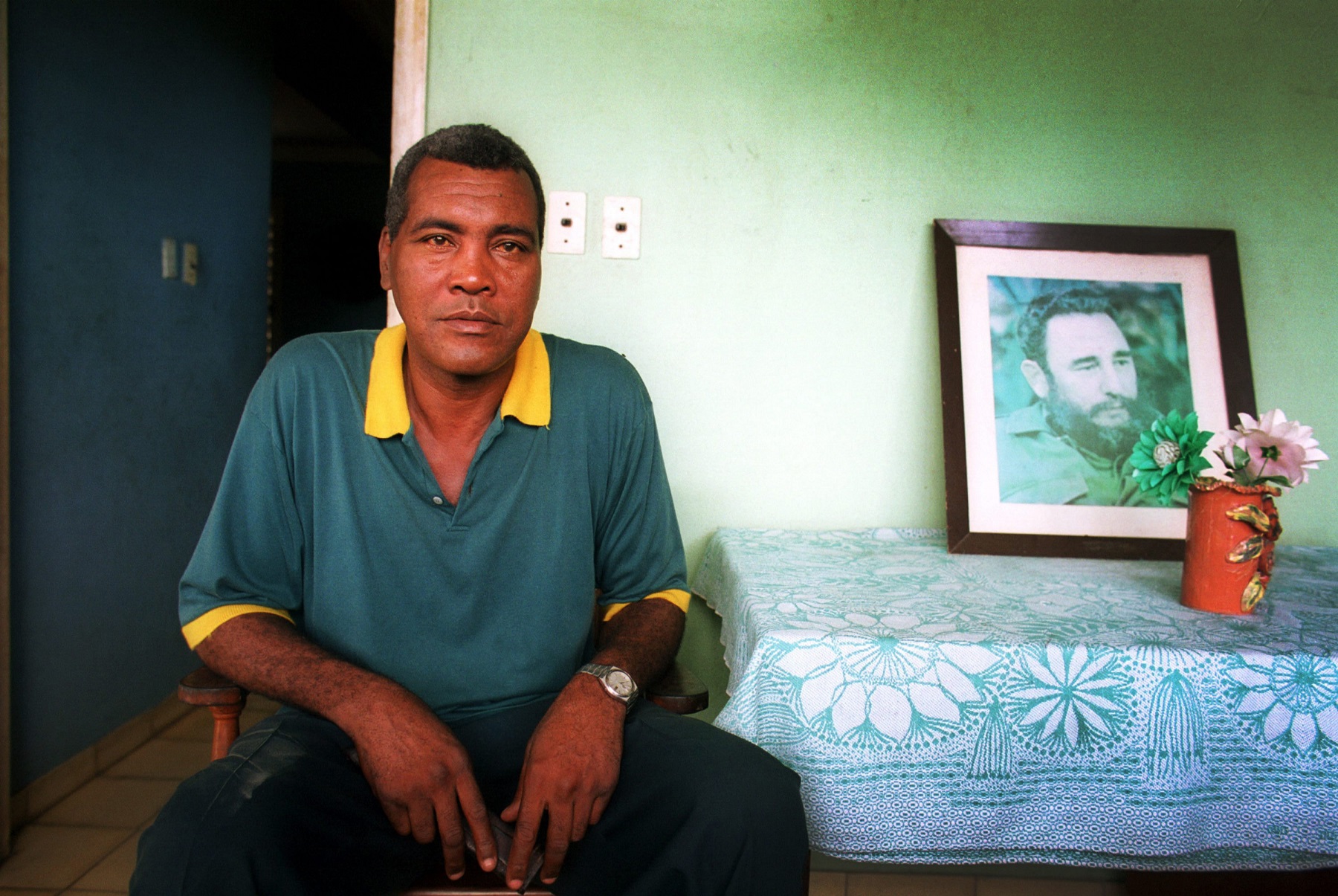 DELICIAS, CUBA - JULY 30: Cuba’s boxing legend Teofilo Stevenson sits next to a photo of Cuba’s Revolution leader Fidel Castro in his home in Delicias on July 30, 2000, in the eastern province Las Tunas, Cuba. Stevenson, who won 3 Olympic Gold medals and was 3 times World Champion, died of heart attack at the age of 60 on June 11, 2012, in Havana, Cuba. (Photo by Sven Creutzmann/Mambo photo/Getty Images)